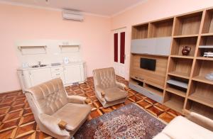 ein Wohnzimmer mit 2 Stühlen und einem TV in der Unterkunft Apartments Casa Menis in Rovinj