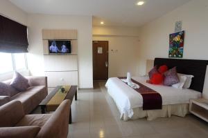 a hotel room with a bed and a couch at Geopark Hotel Kuah Langkawi in Kuah +18 photos
