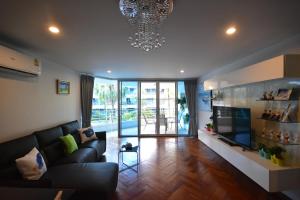 a living room with a couch and a chandelier at Hua Hin Beachfront Condo in Hua Hin