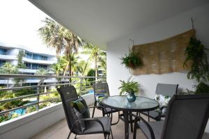 patio ze stołem i krzesłami na balkonie w obiekcie Hua Hin Beachfront Condo w mieście Hua Hin