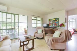 a living room with two chairs and a table at Omati Lodge in Taravao