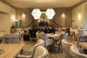 a dining room with tables and chairs and chandeliers at Hotel Resort Märkisches Meer in Diensdorf-Radlow