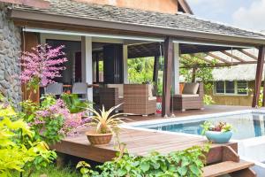 un patio al aire libre con terraza y piscina en Omati Lodge, en Taravao