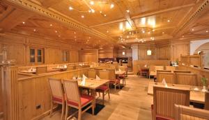 - un restaurant avec des murs en bois, des tables et des chaises en bois dans l'établissement Hotel Randsbergerhof, à Cham