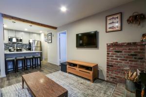 a living room with a tv and a brick wall at La Residence V #S02 Condo in Mammoth Lakes