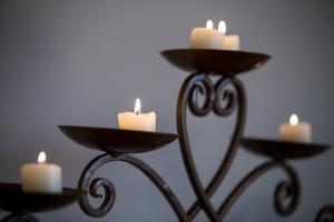 a candle holder with candles in front of a mirror at Afroessa Hotel by Pearl Hotel Collection in Imerovigli