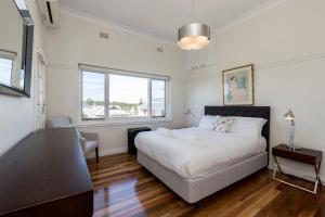 a bedroom with a bed and a window at Cottesloe Beach Deluxe Apartment in Perth