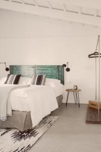 a white bedroom with a large bed and a table at Smoix hotel in Ciutadella