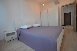 1 dormitorio con 1 cama grande y 2 almohadas en Rya Home, en Bucarest