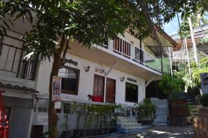 una casa con un árbol delante de ella en Coco's Guest House, en Islas Phi Phi