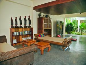 uma sala de estar com um sofá grande e duas mesas em Chanapha Residence em Praia de Tab Kaek