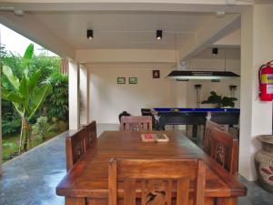 uma sala de jantar com uma mesa de madeira e um piano em Chanapha Residence em Praia de Tab Kaek