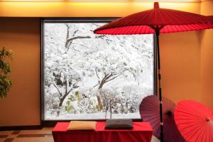 
a red umbrella sitting in front of a window at Yutorelo-an in Hakone
