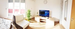 a living room with a television and a white couch at Penthouse Spudic Karlovac in Karlovac