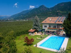 an aerial view of a house with a swimming pool at Hotel Sonnenhof in Lana