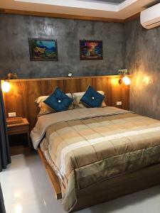 een slaapkamer met een groot bed met blauwe kussens bij Lanta Sabai Day House in Koh Lanta