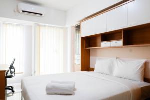 スラバヤにあるStrategic Studio Apartment at Orchard Mansion Supermall By Travelioのベッドルーム1室(白いベッド1台、白い枕付)