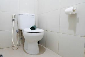 スラバヤにあるStrategic Studio Apartment at Orchard Mansion Supermall By Travelioのバスルーム(緑のタオル付きトイレ付) +5枚の写真