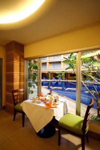 a dining room with a table and a large window at Kalim Resort - SHA Plus in Patong Beach