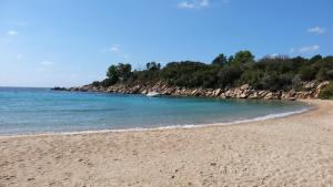 une plage de sable avec un bateau dans l'eau dans l'établissement MARE BELLU AGOSTA PLAGE, à Albitreccia