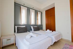 two white beds in a room with windows at Bozis Private Pool Villa, Siviri in Siviri +31 photos
