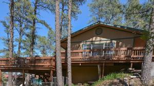 a house with a large deck in the woods at Tanglewood, Cabin at Ruidoso, with Forest View in Ruidoso