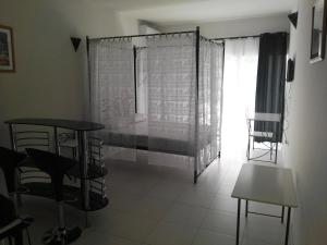 un soggiorno con tavolo, sedie e finestra di Residencial Casa da Luz a Mindelo