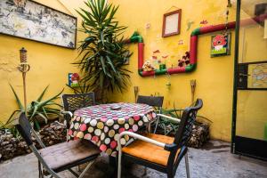 a table and chairs in a patio with a yellow wall at Five Trees in Sliema