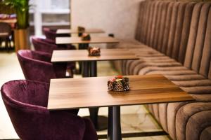 a row of tables and purple chairs in a restaurant at Hotel Ideja in Banja Luka