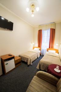 ein Hotelzimmer mit 2 Betten und einem Sofa in der Unterkunft Амулет на Большом in Sankt Petersburg
