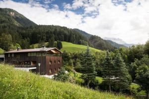 a building on a hill in a valley with trees at Chalet Vanzi in San Martino in Badia