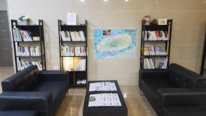 two couches and a table in a book store at Hotel Aroha in Seogwipo