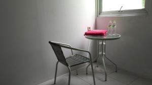 a table with a chair and a table with a pink pillow at Uni Inn Semarang - Gunung Pati in Semarang