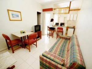 a living room with a couch and a table and a kitchen at Residencial Porto Farol in Salvador