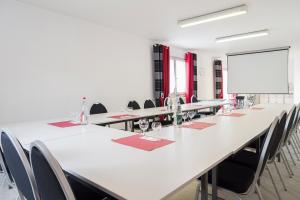 a large conference room with a long table and chairs at The Originals City, Hôtel La Siesta, Annonay Est in Davézieux +44 photos