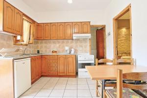 Almiros BeachにあるAmarylis Apartmentのキッチン(木製キャビネット、テーブル、テーブル、テーブル付) +24枚の写真