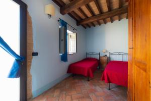 ピエーヴァ・スクオーラにあるCasa Vernianoの赤いシーツが備わるベッド2台付きの部屋