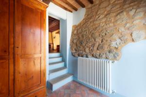 uma escada numa casa com uma parede de pedra em Casa Verniano em Pieve a Scuola