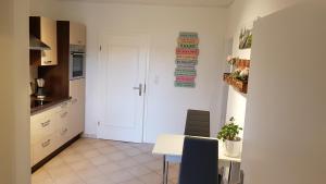 una cucina con tavolo e porta bianca di Ruhige Ferienwohnung direkt am Nord-Ostsee-Kanal a Breiholz Altre 17 foto
