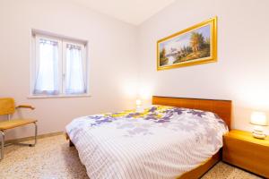 a bedroom with a bed and a picture on the wall at Sorrento's House in Sant'Agnello