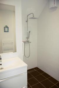 a white bathroom with a shower and a sink at Marshlands Apartment in Lewes