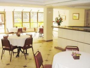 a dining room with tables and chairs in a room at Residencial Porto Farol in Salvador +11 photos