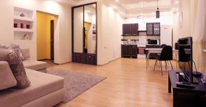 チェレポヴェツにあるАпартаменты в центре Череповцаのリビングルーム(ソファ、テーブル付)、キッチンが備わります。