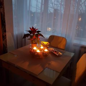 a table with a vase of flowers and candles on it at B-Est Lilleküla Apartment in Tallinn