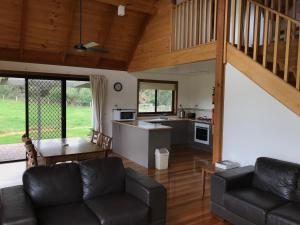 sala de estar con sofá y mesa en Prom Coast Holiday Lodge, en Waratah Bay