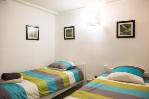 ソール・オスゴールにあるVILLA SEA AND SURFのベッドルーム1室(ベッド2台付)が備わります。壁に2枚の写真が飾られています。