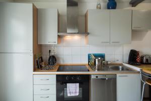 a kitchen with white cabinets and a black dishwasher at VILLA SEA AND SURF in Soorts-Hossegor +14 photos