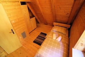 uma vista sobre uma cama num quarto de madeira em House Marko Breze em Ledenice