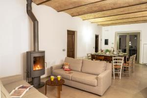 - un salon avec un canapé et une cheminée dans l'établissement Agriturismo Montelovesco, à Brunetta