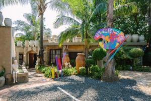 a garden with a palm tree and a building at The Art Guesthouse in Hartbeespoort